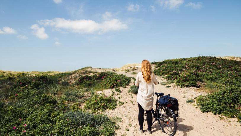 Fahrradfahrerin auf dem Nordküstenradweg in Nordseeland an der Dänischen Ostsee