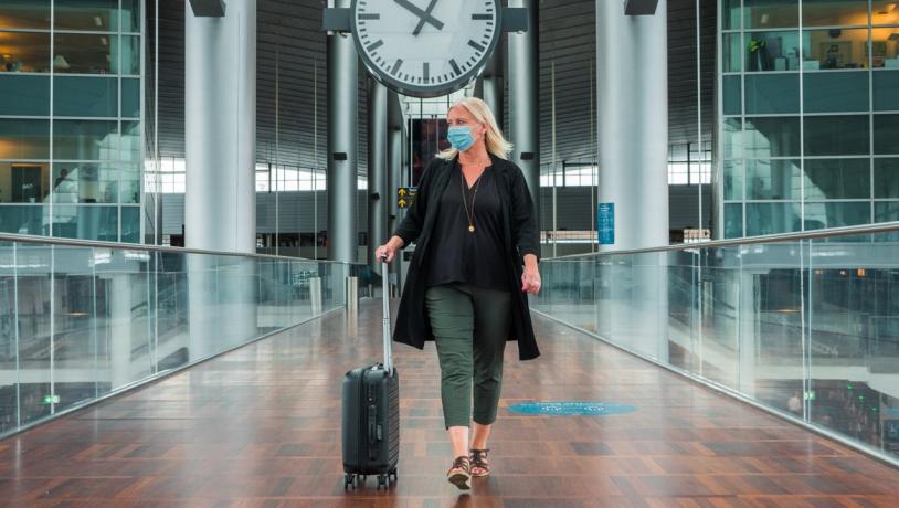 A woman walks through Copenhagen airport in a face mask during the coronavirus period