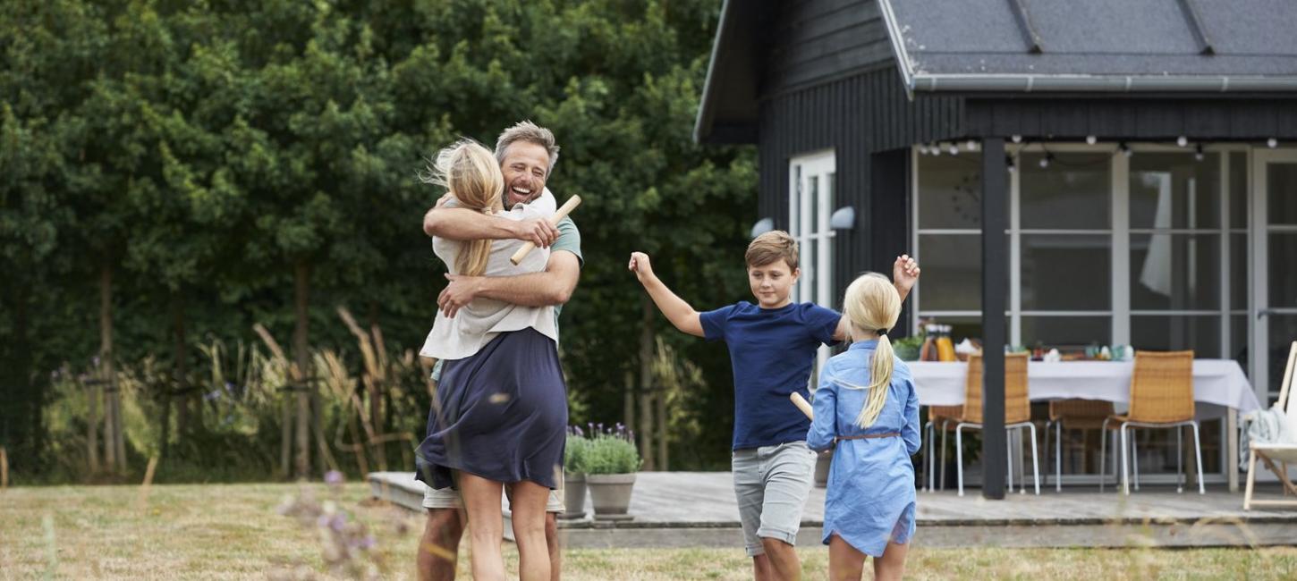 Familie vor Sommerhaus in Dänemark