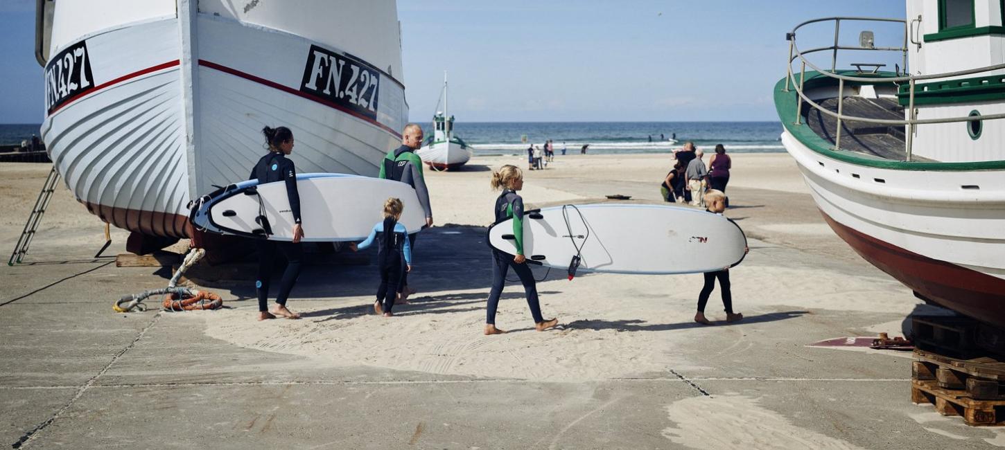 Family with surfboards on the beach at Løkken in North Jutland
