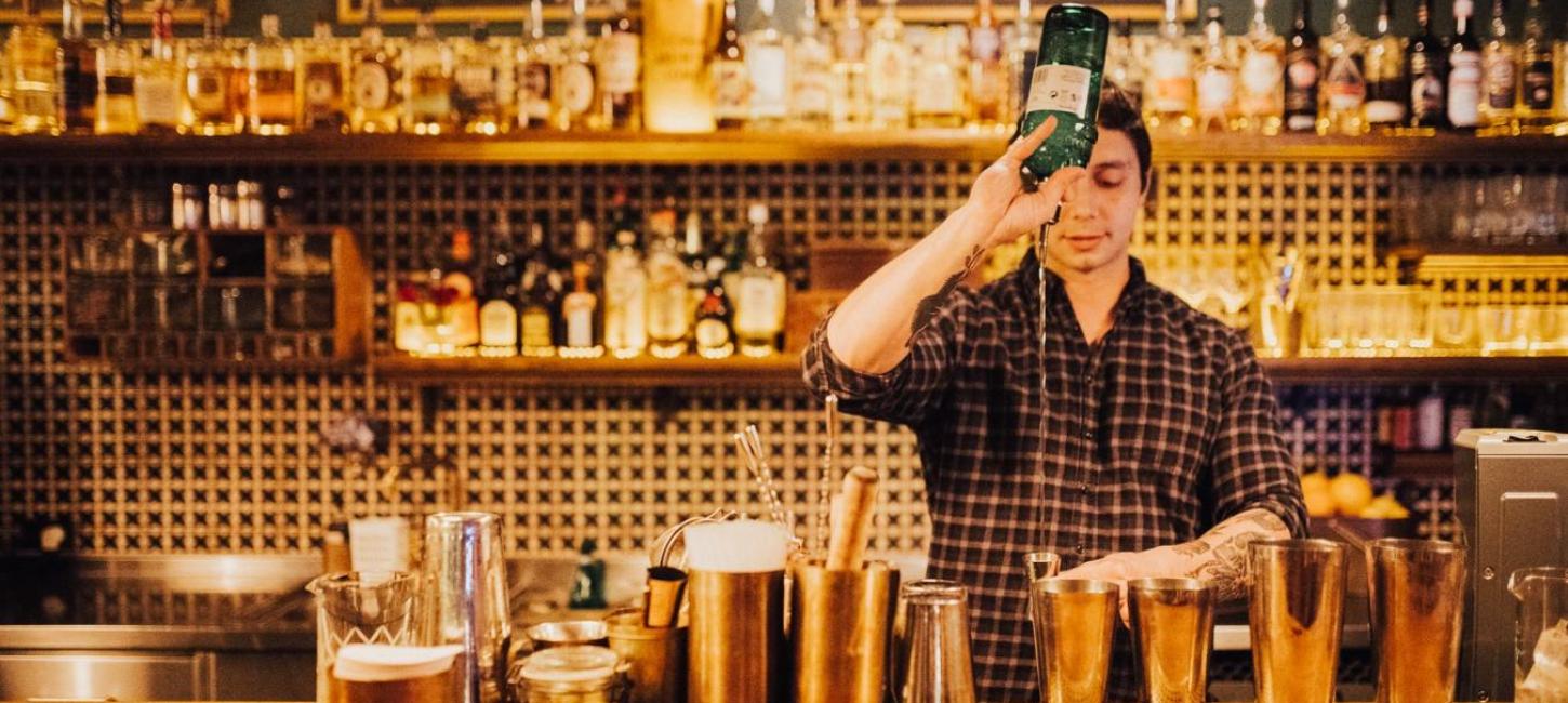 bartender mikser cocktails ved baren Lidkoeb i København, Danmark