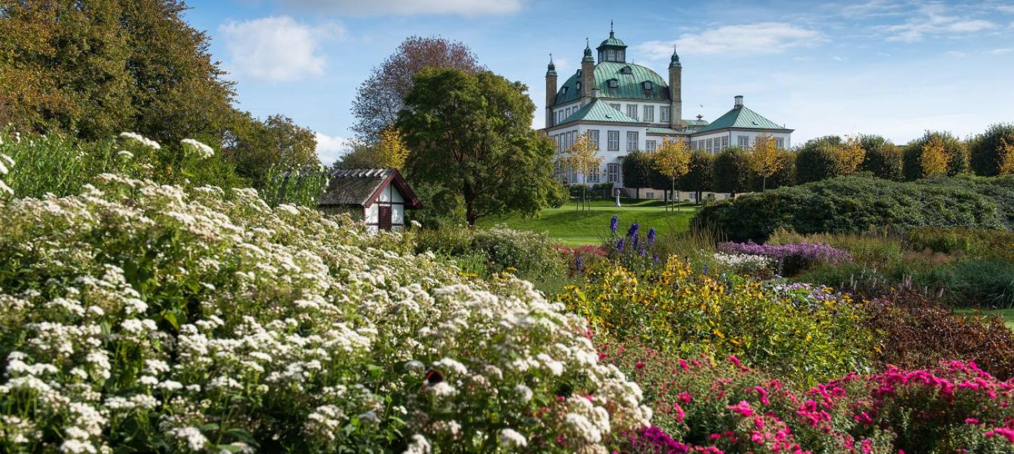 Fredensborg Schlossgarten mit Blumen im Vordergrund und dem Schloss im Hintergrund