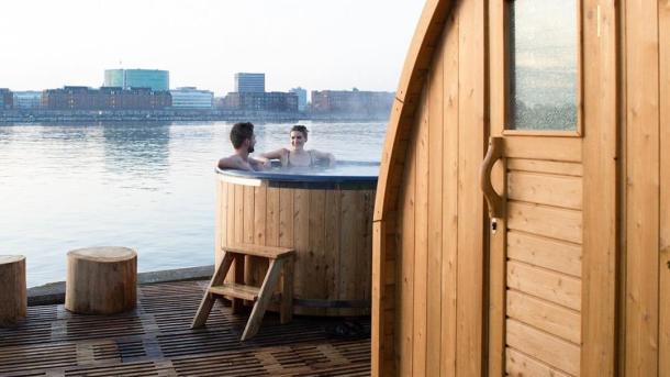 A couple enjoying the hot tub and sauna at CopenHot in Copenhagen