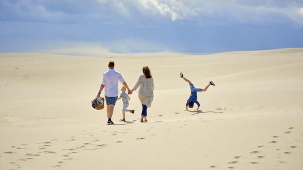 A family walking through the migrating dune, Raabjerg Mile in North Jutland.