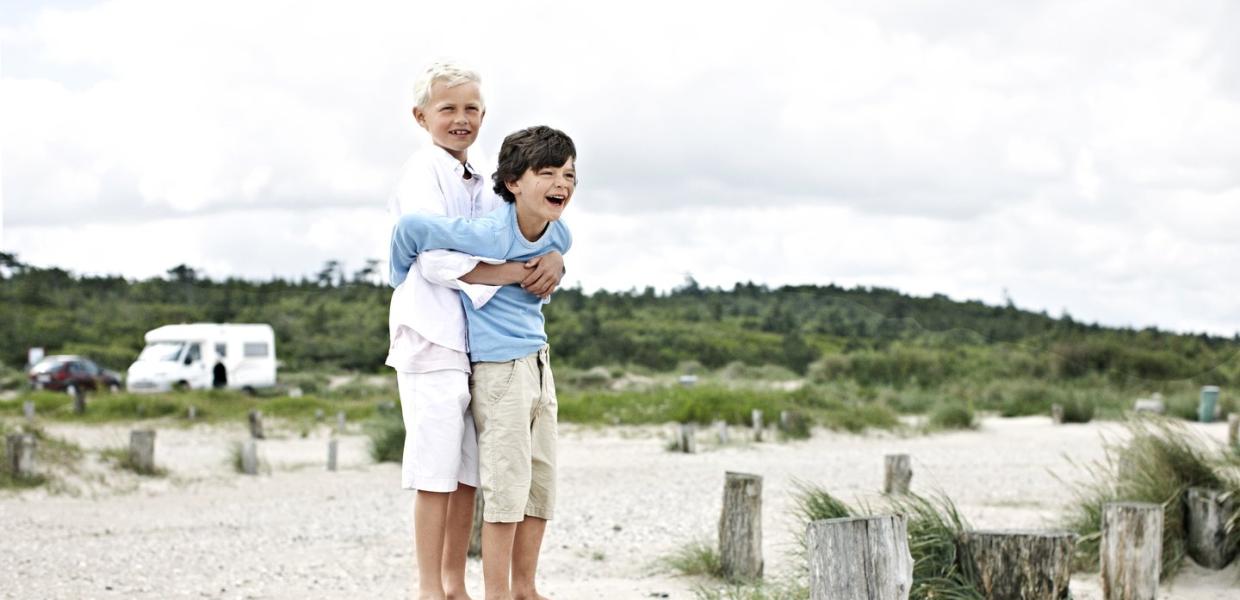 To barn leker på stranden nært en campingplass i Danmark