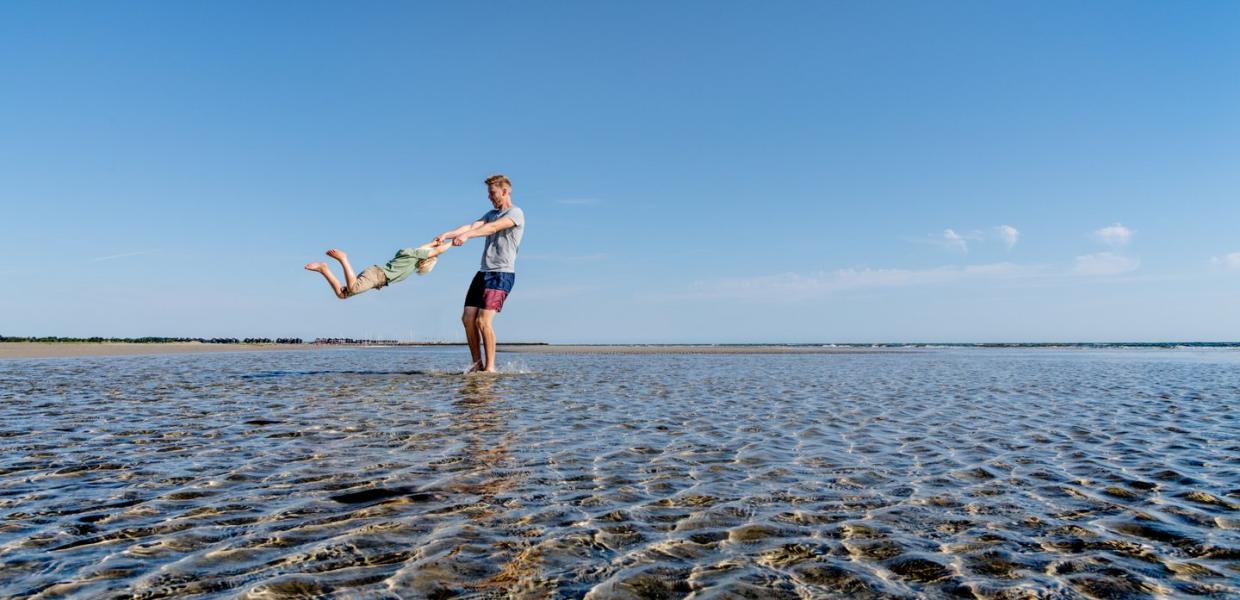 Vater spiel mit seinem Kind am Strand von Øster Hurup, Dänemark