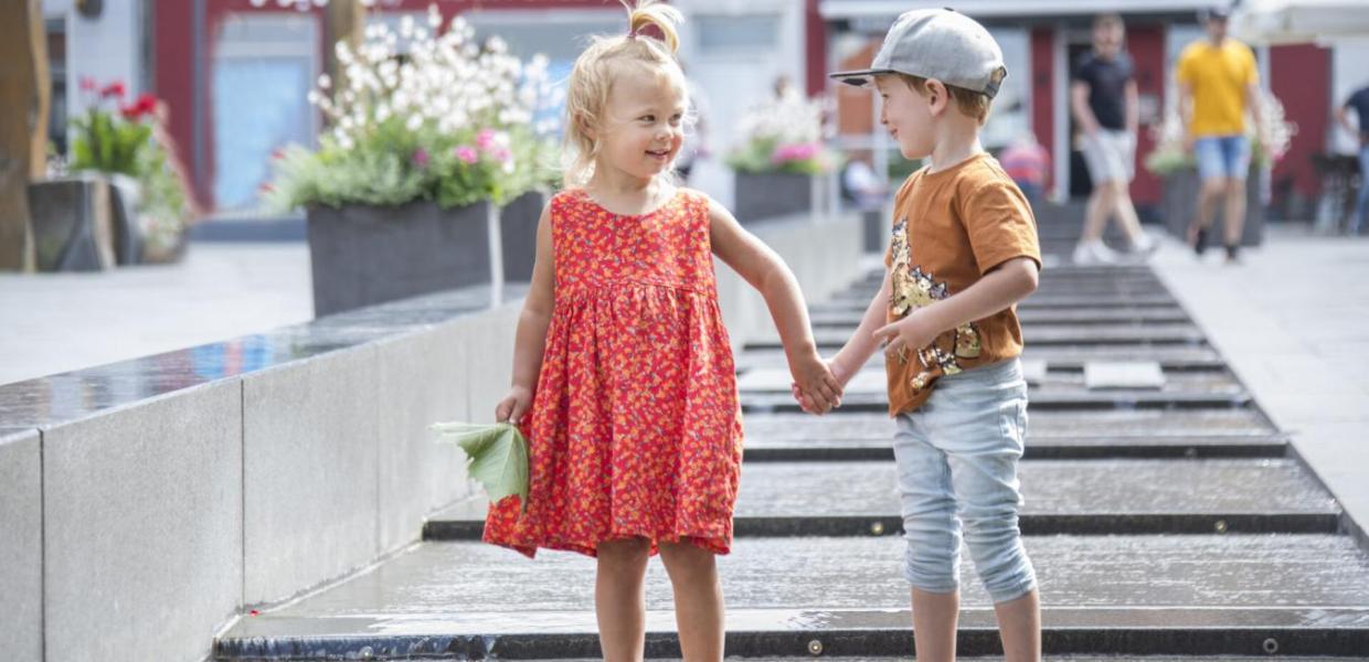 En liten jente og gutt holder hender i sentrum av Slagelse, Vestsjælland, Danmark