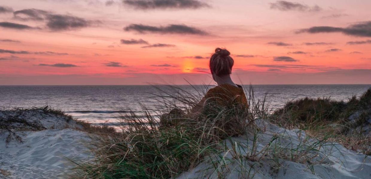 Woman watching the sunset on Søndervig beach, Vesterhavet