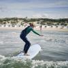 Jente som surfer på Løkken strand