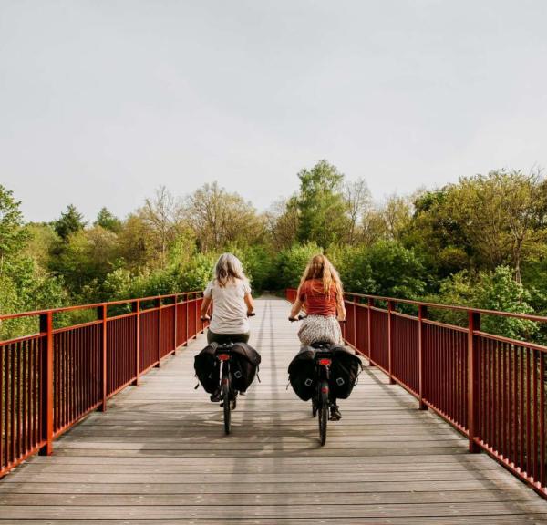 To kvinner sykler over Den Genfundne Bro, nær Horsens, region Kystlandet, Danmark
