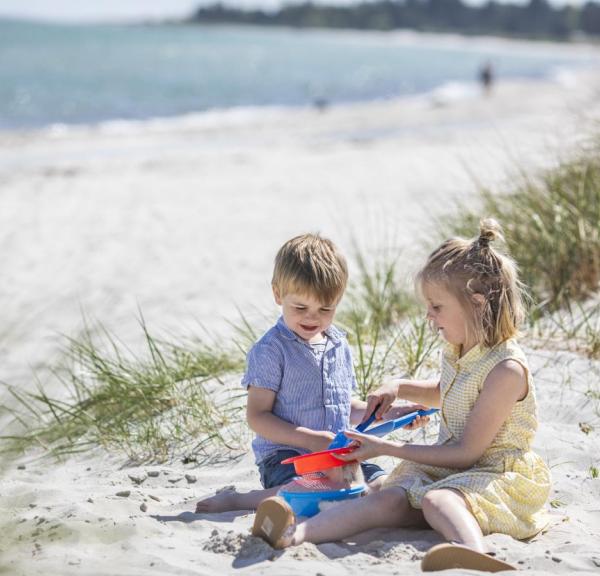 Barn leker i sanden ved Saksild Strand i Kystlandet, Danmark