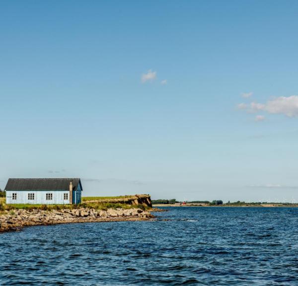 Et lite hus ved vannet på øya Jegindø i Limfjorden, Danmark