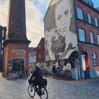 Person cycling past street art in Odense, on Fyn