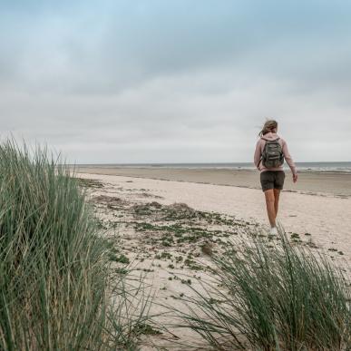 ung kvinne går tur langs stranden på Fanø
