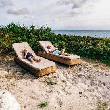 To gutter på loungestoler på Grenaa Strand i Djursland, Danmark