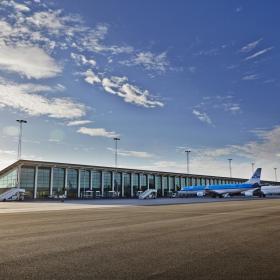 Aalborg flyplass med tre fly parkert ved gate
