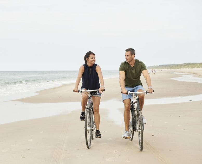 Paar fährt Fahrrad am Strand von Hirtshals in Nordjütland