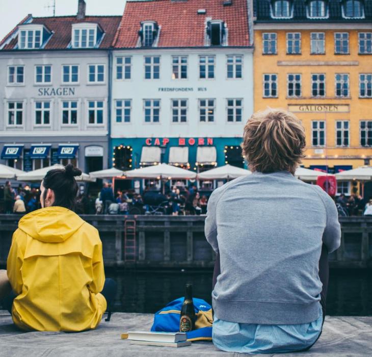 People sitting by the dock in Nyhavn, Copenhagen