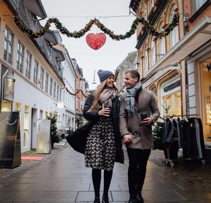 Par går langs juledekorert gågate i Aalborg, Danmark